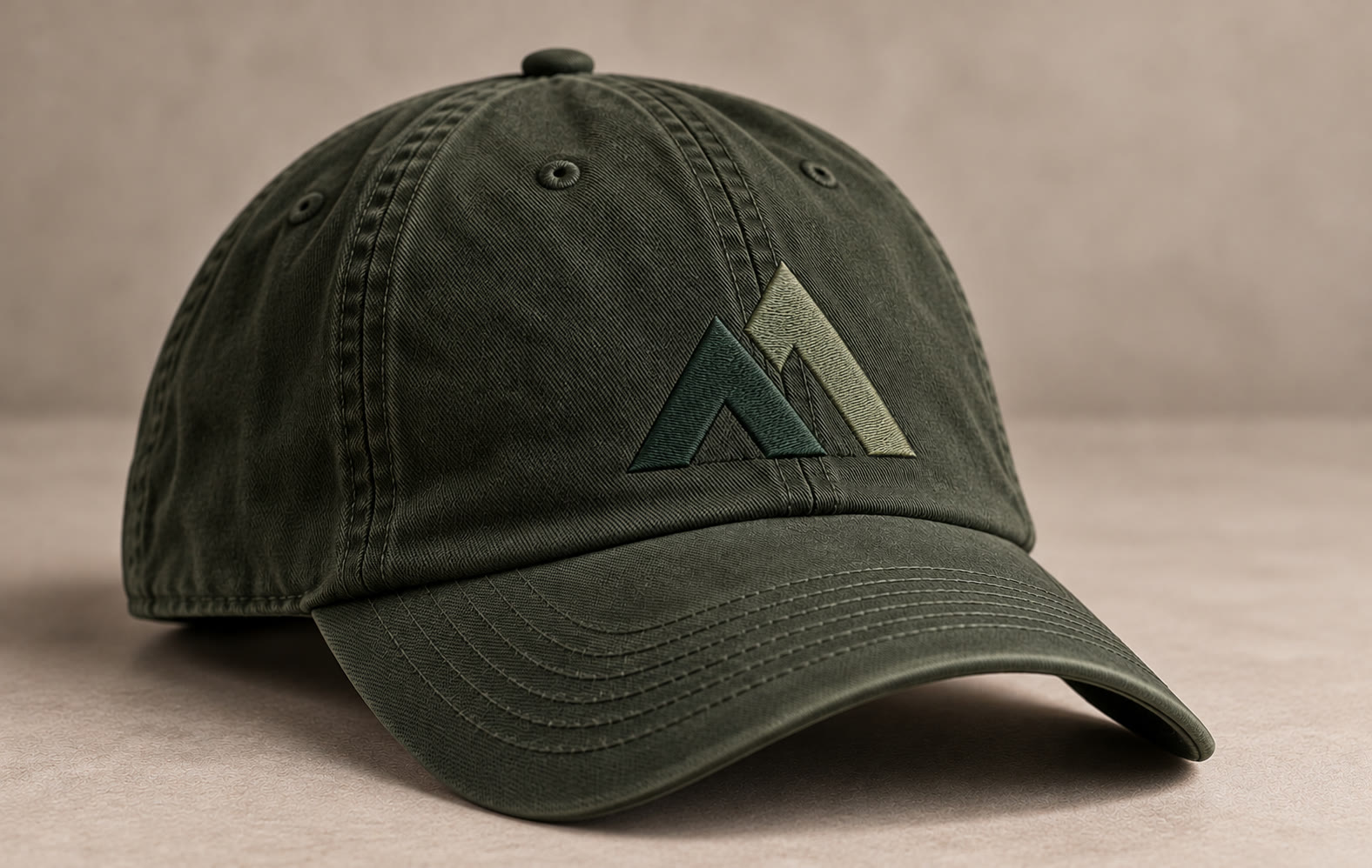 A washed green ballcap with the emblem embroidered in Spruce and Moss.